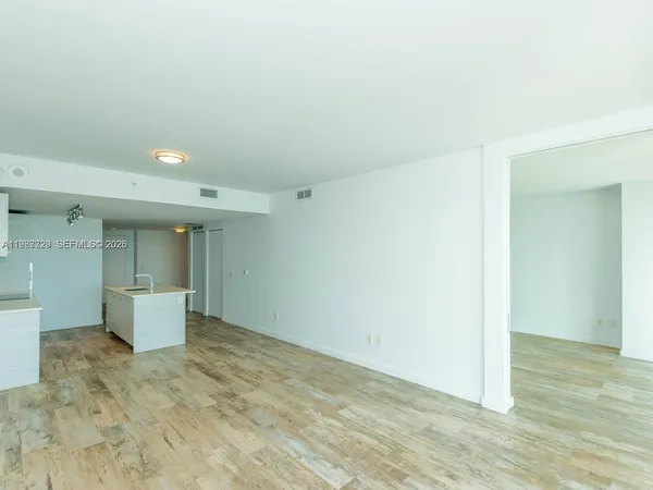 a living room with furniture a flat screen tv and a chandelier