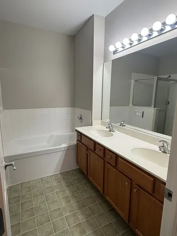 a bathroom with a granite countertop sink toilet a mirror and bathtub