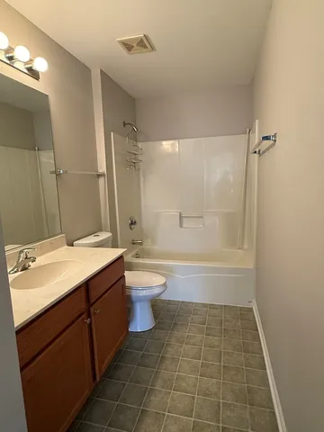 an empty room with windows and ceiling fan