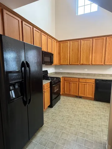 a kitchen with stainless steel appliances granite countertop a refrigerator a sink a stove with wooden cabinets