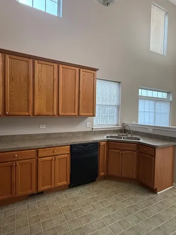 a large kitchen with granite countertop a sink and cabinets