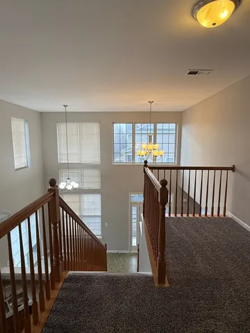 a view of a hallway to a dining room with windows