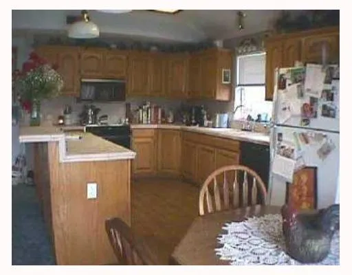 a kitchen with kitchen island granite countertop a sink cabinets and stainless steel appliances