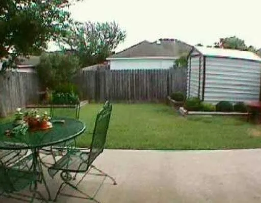 a backyard of a house with table and chairs