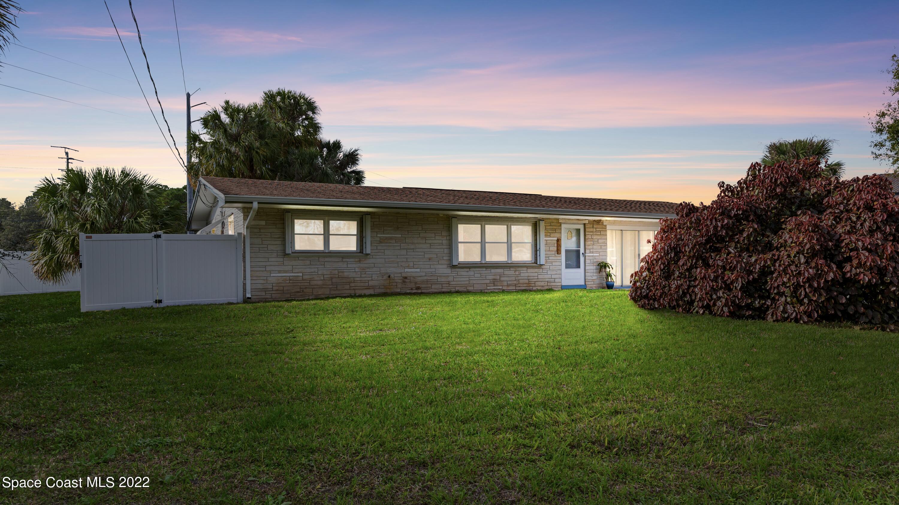 a front view of a house with a garden