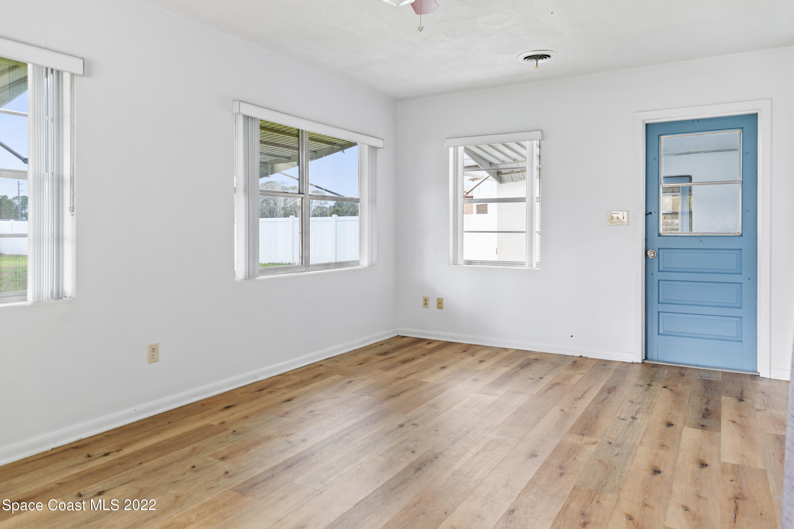 1709 Pinewood Road Melbourne, FL 32934 - Photo 11 of 38 a view of empty room with wooden floor and fan
