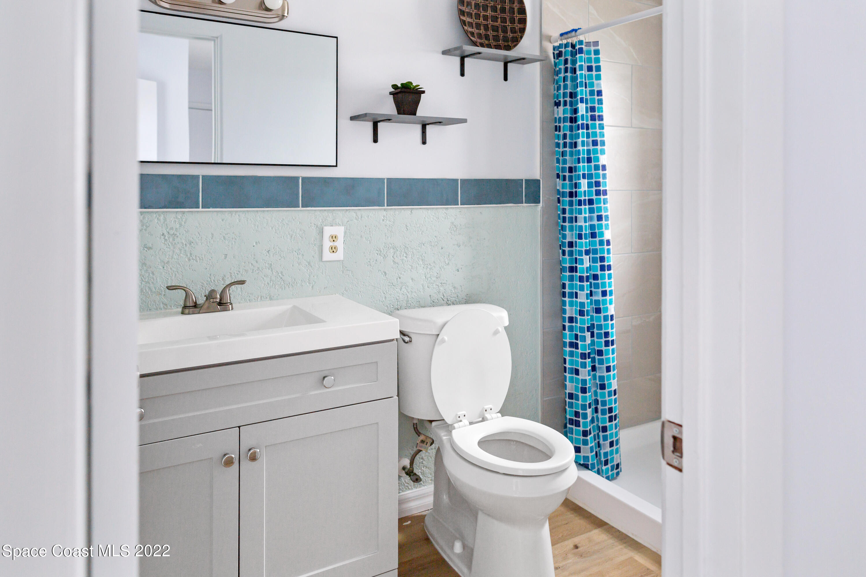 1709 Pinewood Road Melbourne, FL 32934 - Photo 17 of 38 a bathroom with a sink a toilet and a mirror