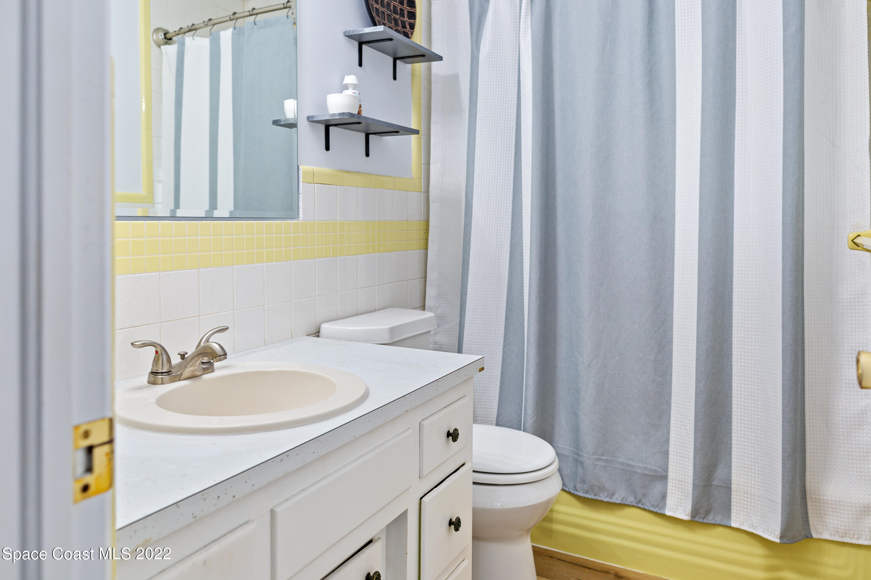 1709 Pinewood Road Melbourne, FL 32934 - Photo 32 of 38 a bathroom with a sink a toilet and shower curtain