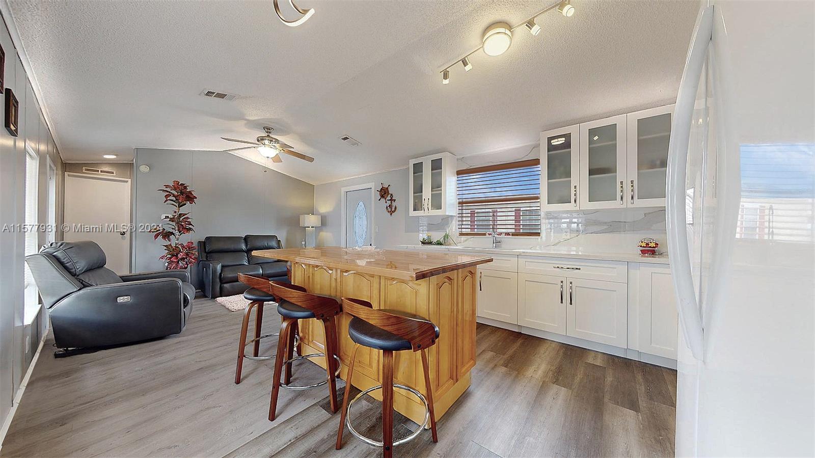 a kitchen with stainless steel appliances granite countertop a kitchen island hardwood floor sink stove dining table and chairs