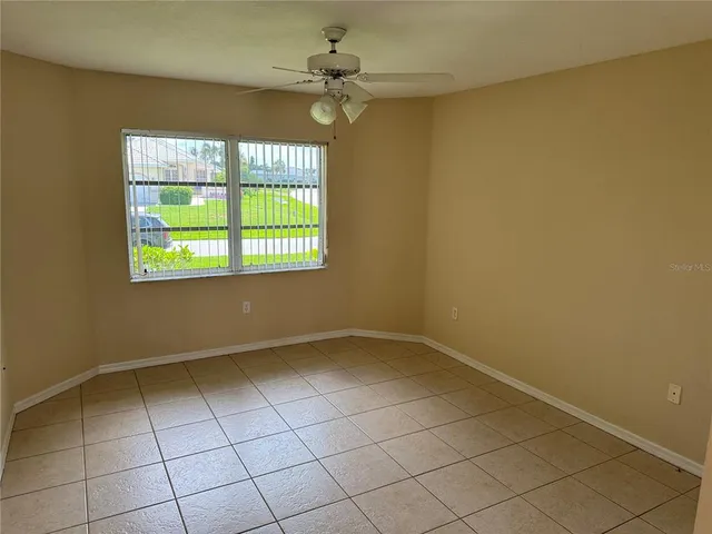 an empty room with windows and fan