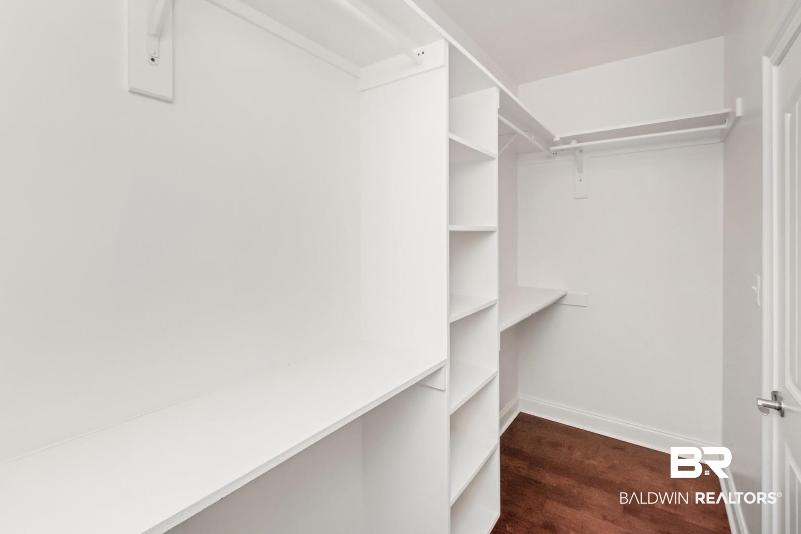 3528 Rue Royal Mobile, AL 36693 - Photo 30 of 53 Custom closet system featuring white shelving, multiple hanging rods, and wood-finish flooring