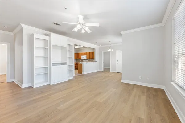 a view of empty room with wooden floor and window