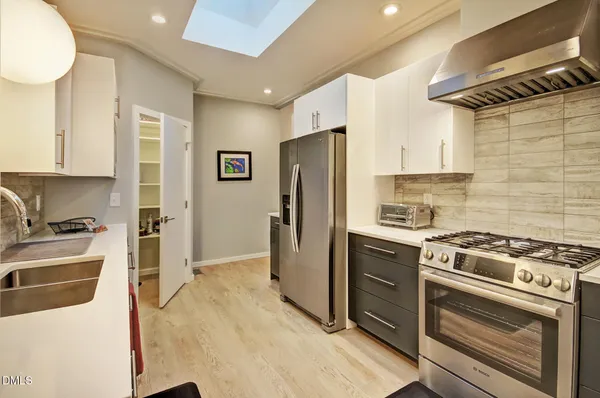 a open kitchen with stainless steel appliances granite countertop a refrigerator and a sink