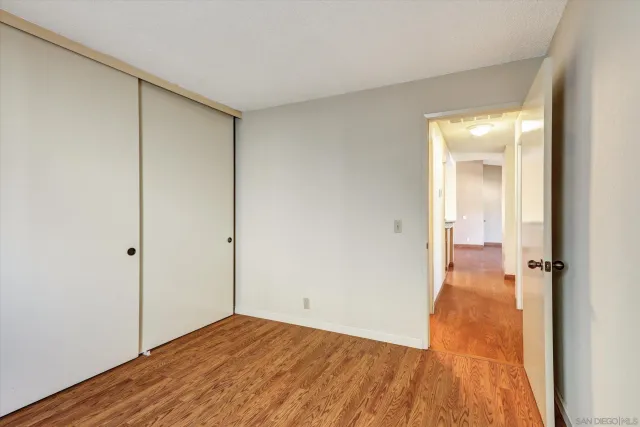 a view of a room with wooden floor and a bathroom