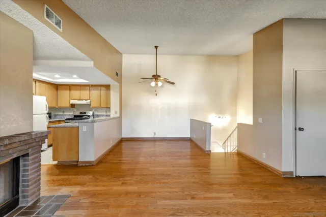a view of a kitchen with kitchen island granite countertop a refrigerator and a sink