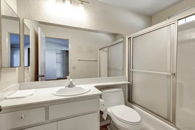 a bathroom with a sink toilet a mirror and shower