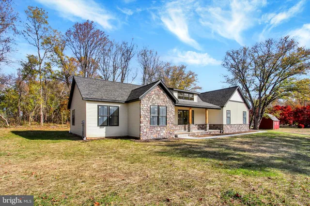 a front view of a house with a garden and trees