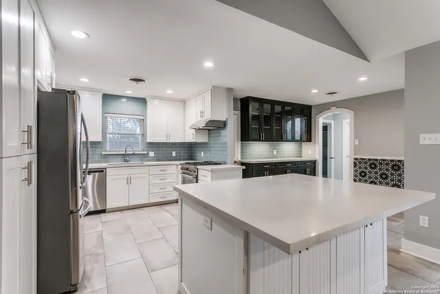 a kitchen with stainless steel appliances a refrigerator sink stove microwave and cabinets