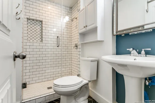 a bathroom with a sink a toilet and shower