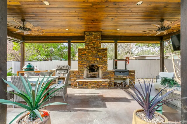 a living room with furniture floor to ceiling window plants and wooden floor