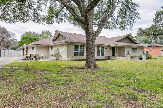 a front view of a house with a garden and trees