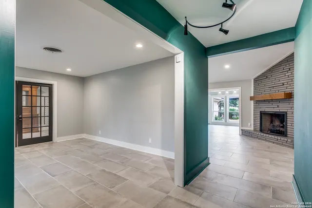 a view of an empty room with window and fire place