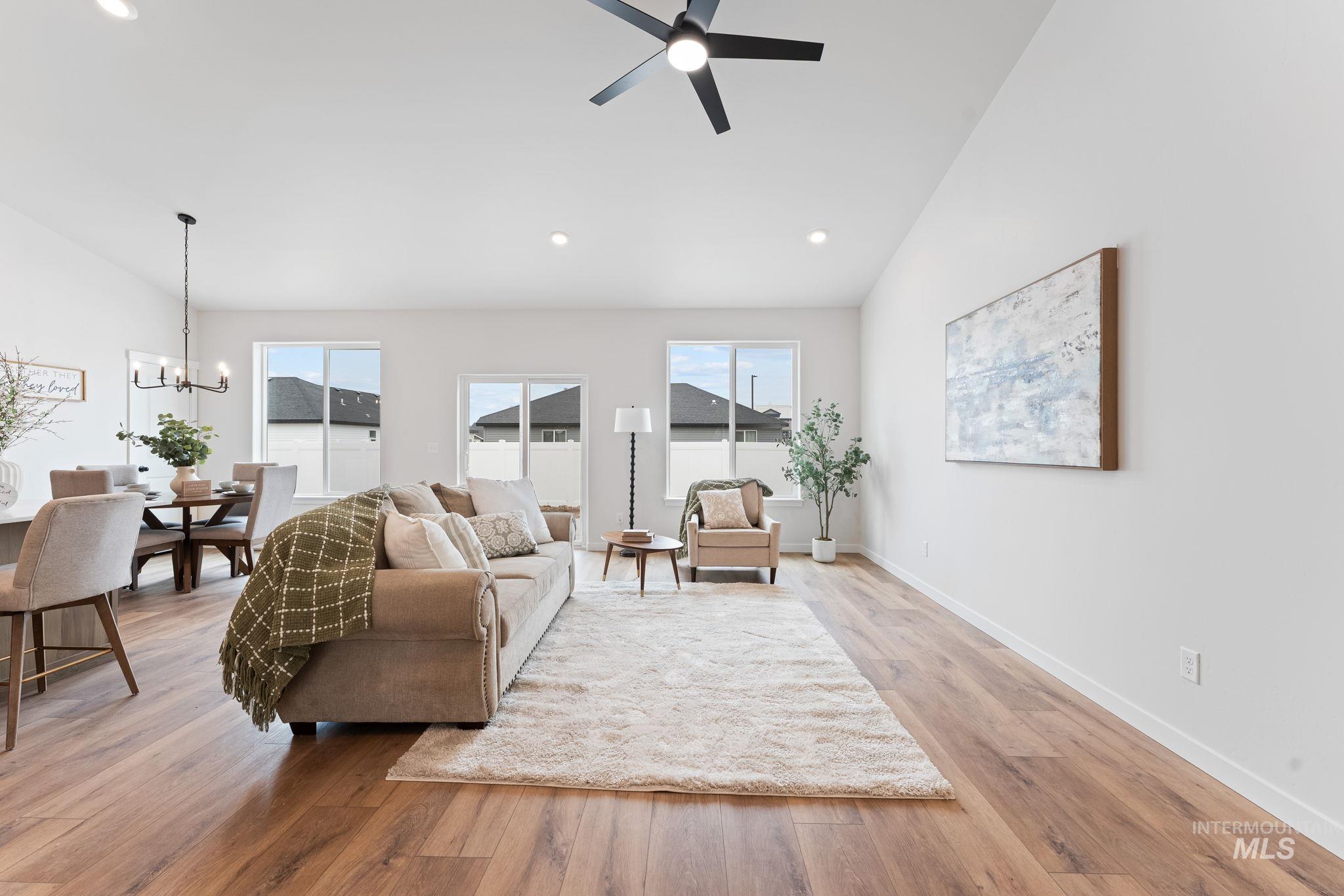 2220 Great Basin Way Burley, ID 83318 - Photo 9 of 39 Living room featuring vaulted ceiling, suspended lighting, light wood-style floors, and ceiling fan