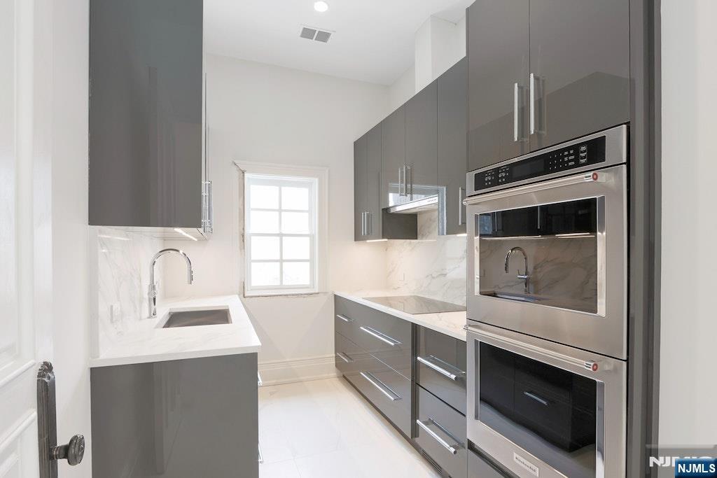 67 Robin Lane Alpine, NJ 07620 - Photo 22 of 40 a kitchen with stainless steel appliances granite countertop a stove microwave and sink