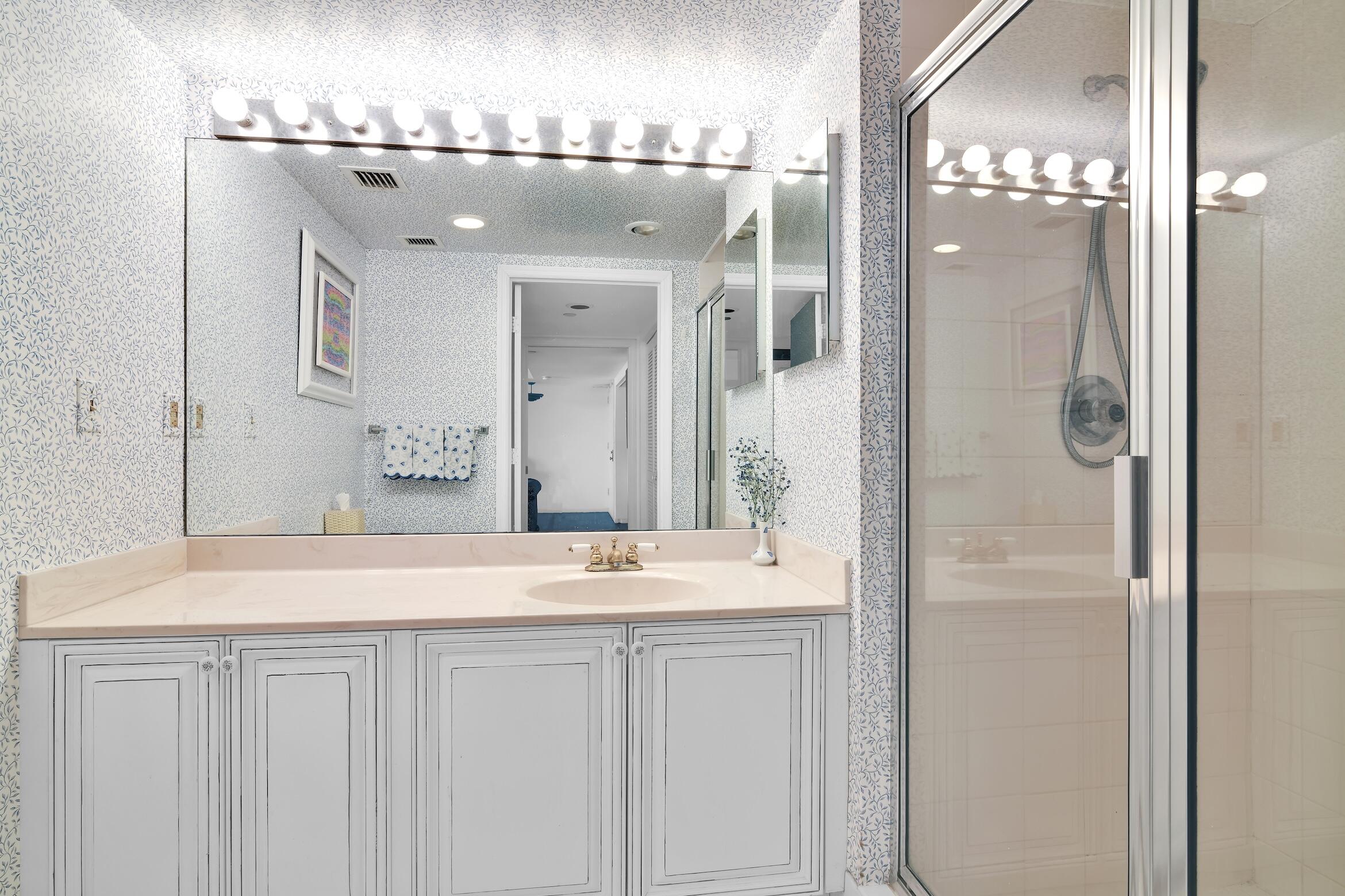 120 Southeast 5th Avenue, Unit 331 Boca Raton, FL 33432 - Photo 12 of 48 a bathroom with a granite countertop sink a mirror and a shower