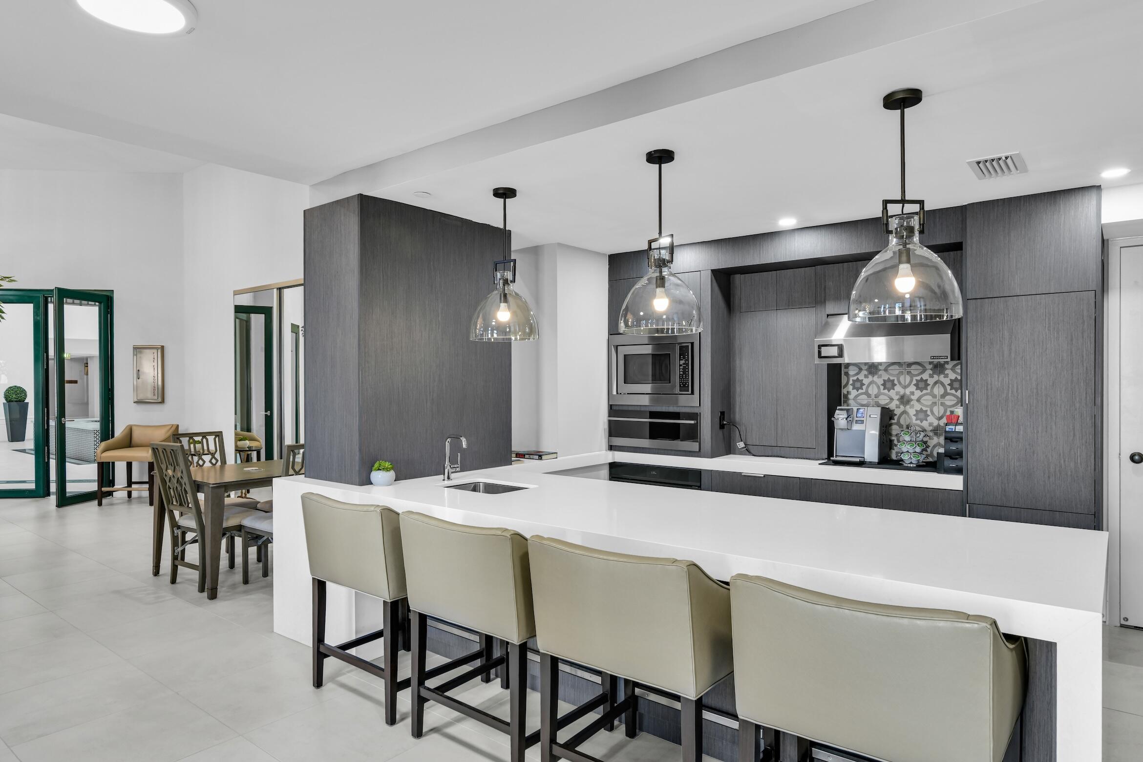 120 Southeast 5th Avenue, Unit 331 Boca Raton, FL 33432 - Photo 35 of 48 a kitchen with stainless steel appliances a dining table chairs and white cabinets