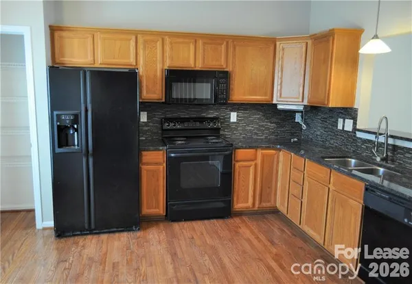 a kitchen with stainless steel appliances granite countertop a stove a sink and a refrigerator
