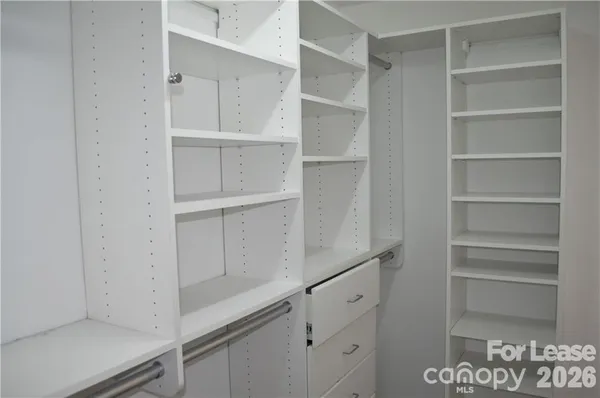 a view of walk in closet with empty racks