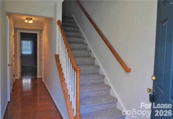 a view of staircase with wooden floor and white walls