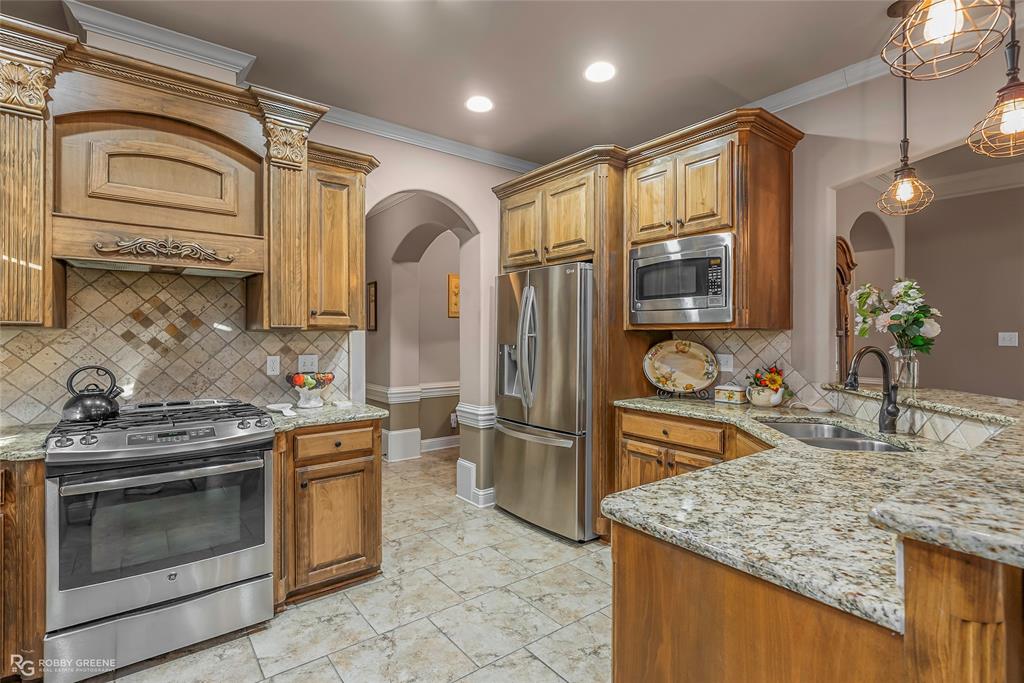 110 St Andrews Benton, LA 71006 - Photo 11 of 28 a kitchen with stainless steel appliances granite countertop a sink stove and refrigerator