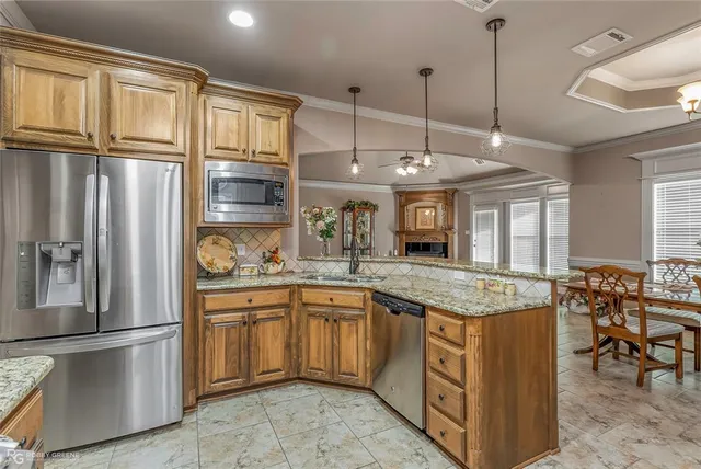 a kitchen with stainless steel appliances granite countertop a sink refrigerator and cabinets