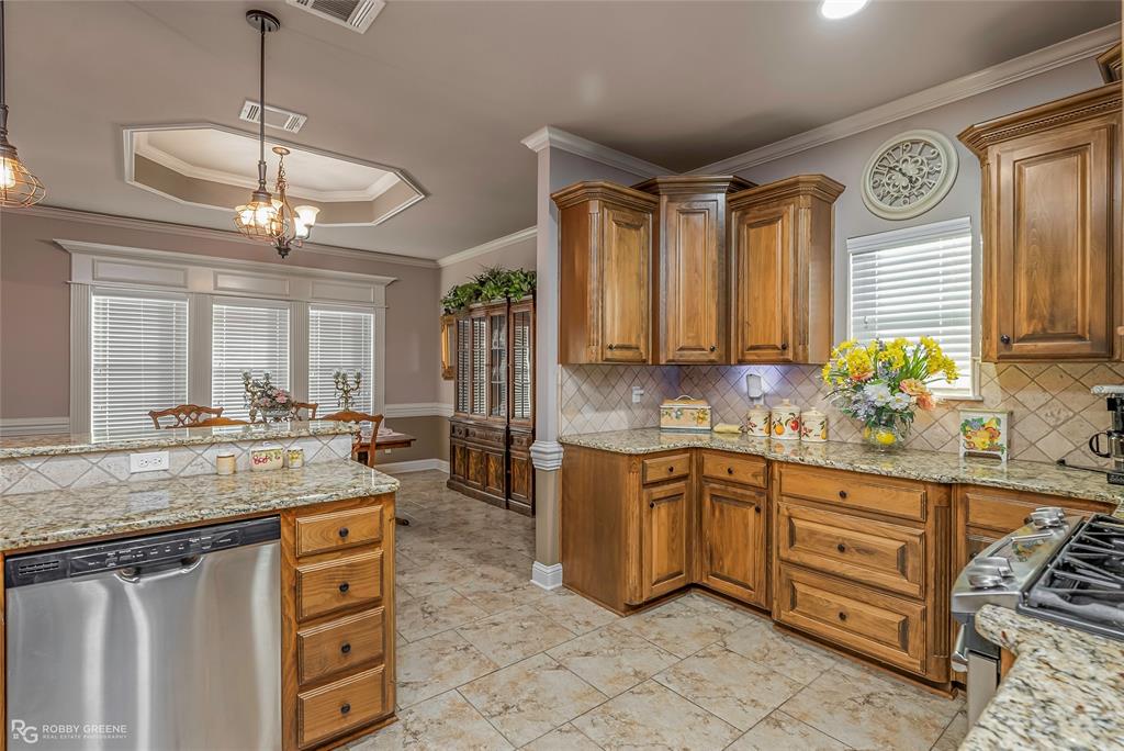 110 St Andrews Benton, LA 71006 - Photo 13 of 28 a kitchen with stainless steel appliances granite countertop a stove a sink and a wooden cabinets