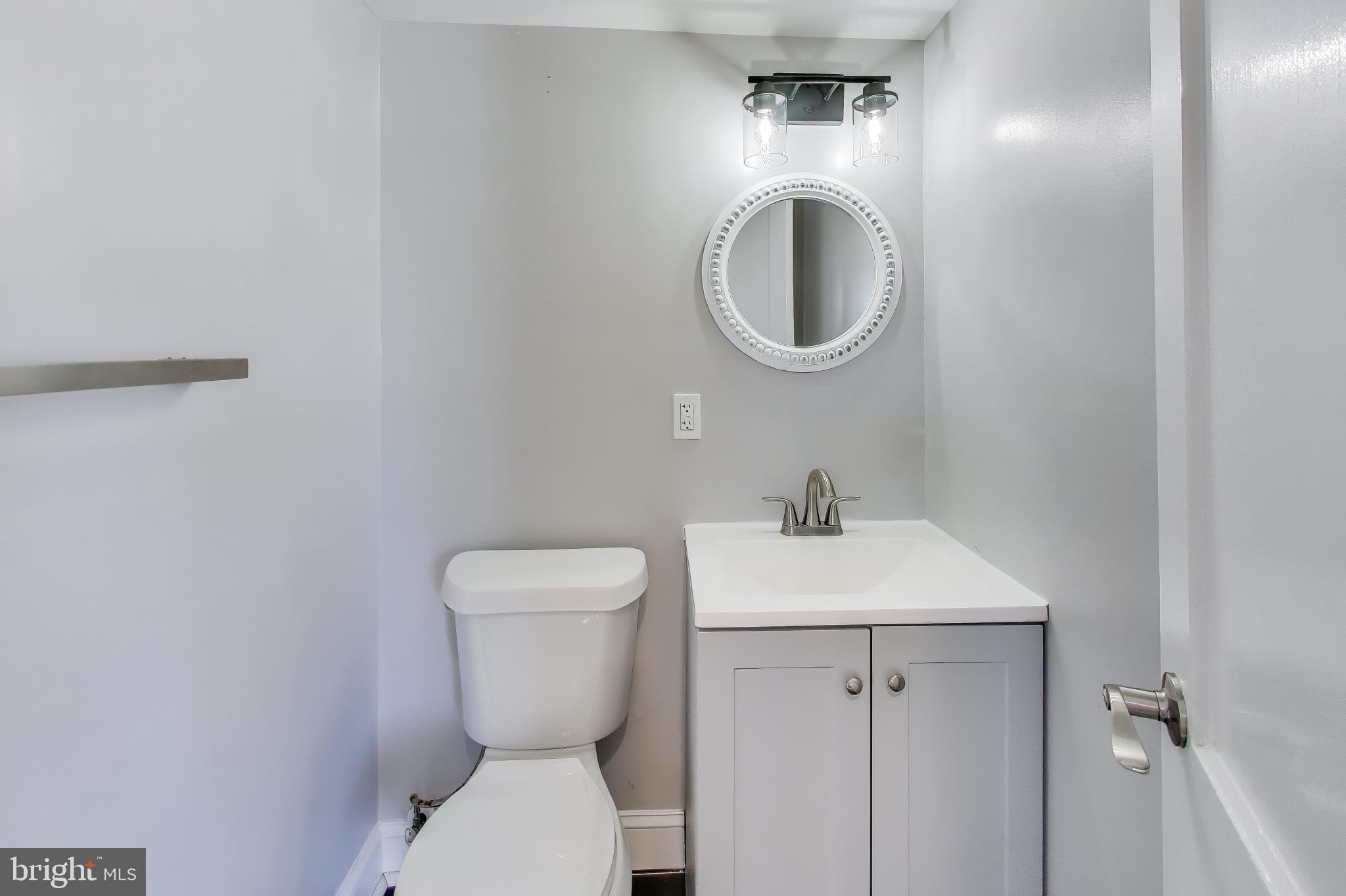6904 Riggs Road Hyattsville, MD 20783 - Photo 11 of 34 a bathroom with a toilet sink and a mirror