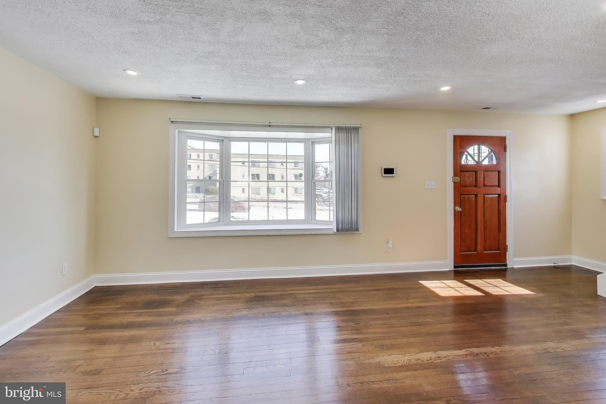 6904 Riggs Road Hyattsville, MD 20783 - Photo 2 of 34 an empty room with wooden floor and windows