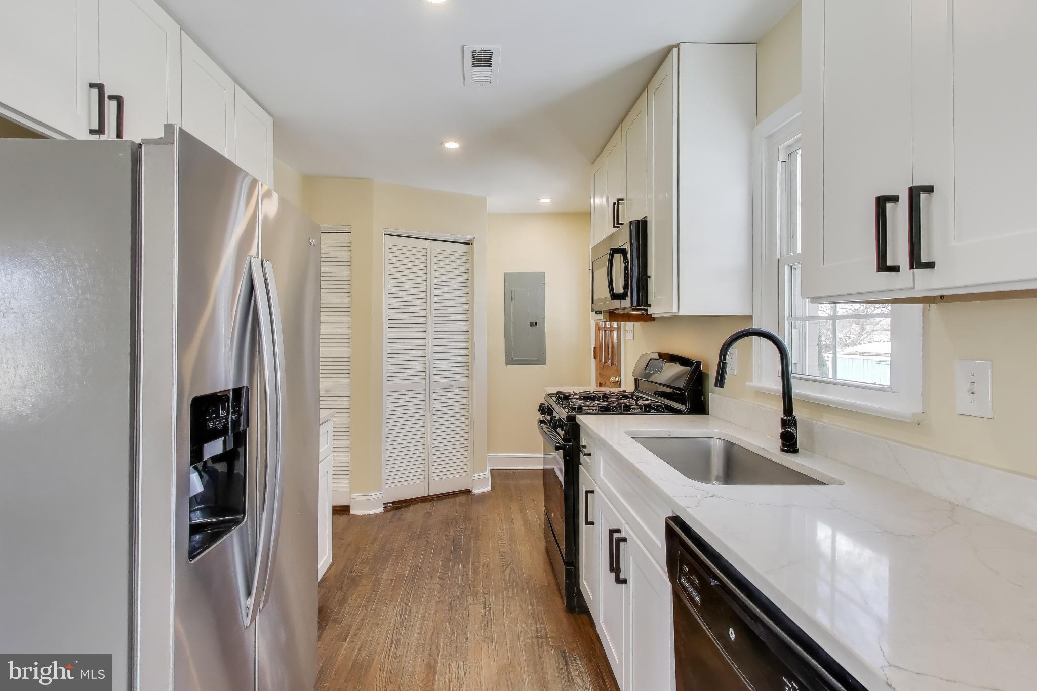 6904 Riggs Road Hyattsville, MD 20783 - Photo 5 of 34 a kitchen with stainless steel appliances a refrigerator sink and stove