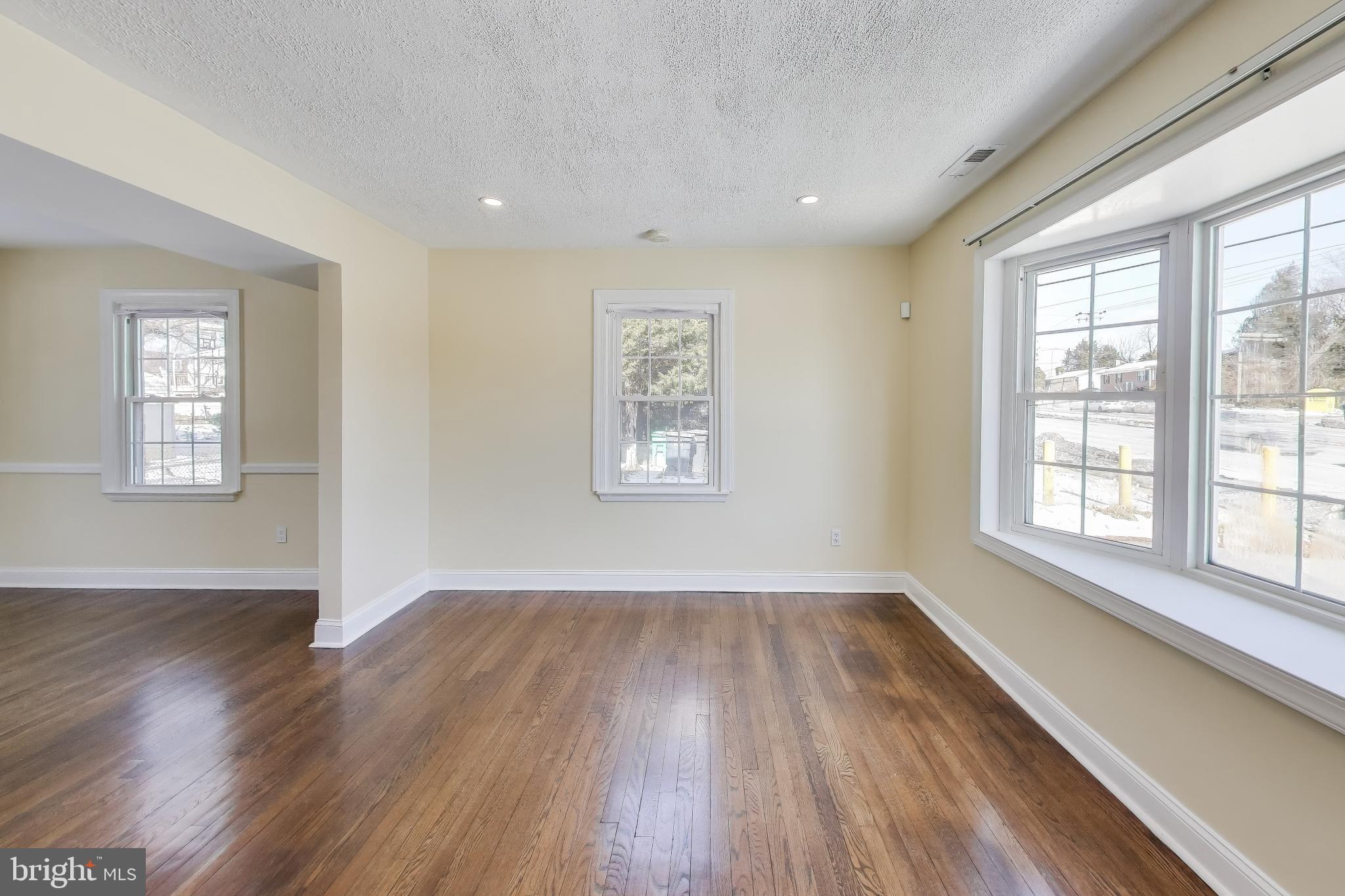 6904 Riggs Road Hyattsville, MD 20783 - Photo 7 of 34 an empty room with wooden floor and windows
