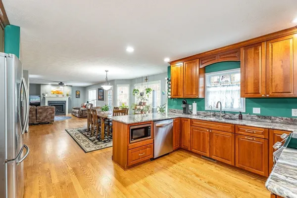 a kitchen with stainless steel appliances granite countertop a refrigerator and a sink
