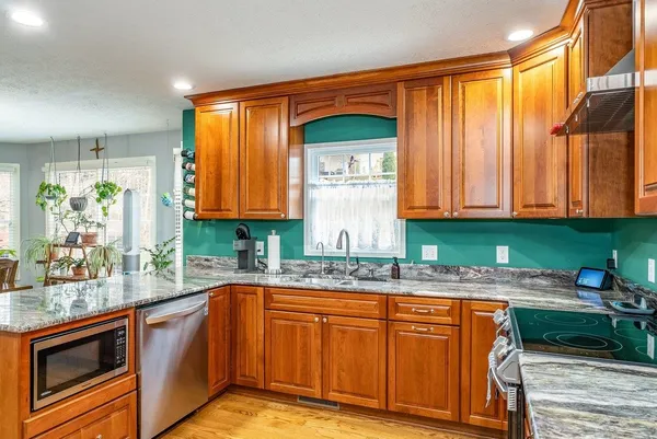 a kitchen with stainless steel appliances granite countertop a refrigerator and a stove top oven