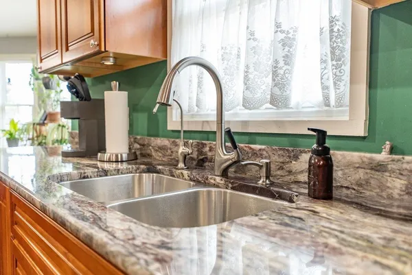 a kitchen with stainless steel appliances granite countertop sink refrigerator and microwave