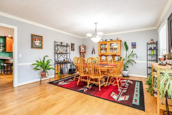 a living room with furniture a chandelier and a flat screen tv