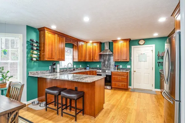 a large kitchen with stainless steel appliances granite countertop a sink and cabinets