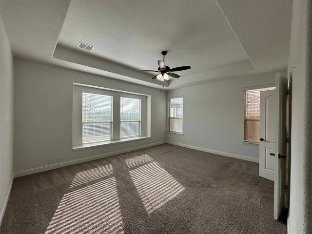 an empty room with windows and fan