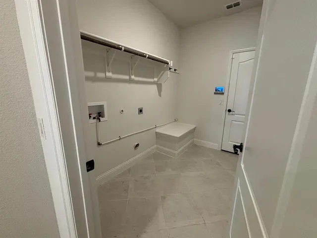 a view of a hallway with wooden floor and a bathroom
