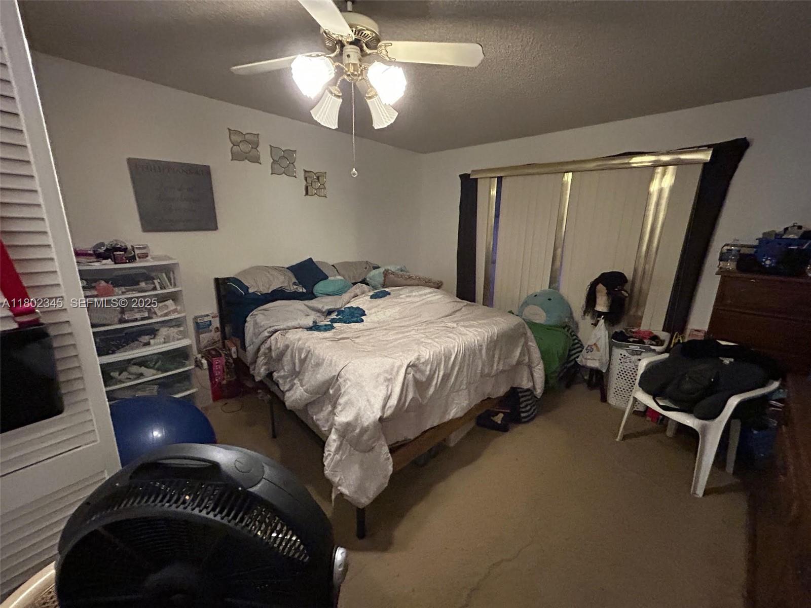 10354 Southwest 173rd Street Miami, FL 33157 - Photo 3 of 12 a bedroom with a bed and a flat tv screen on dresser