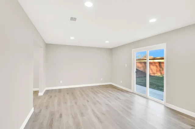 an empty room with wooden floor and sliding door