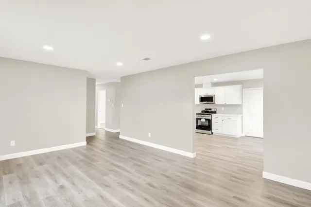 a view of an empty room with wooden floor